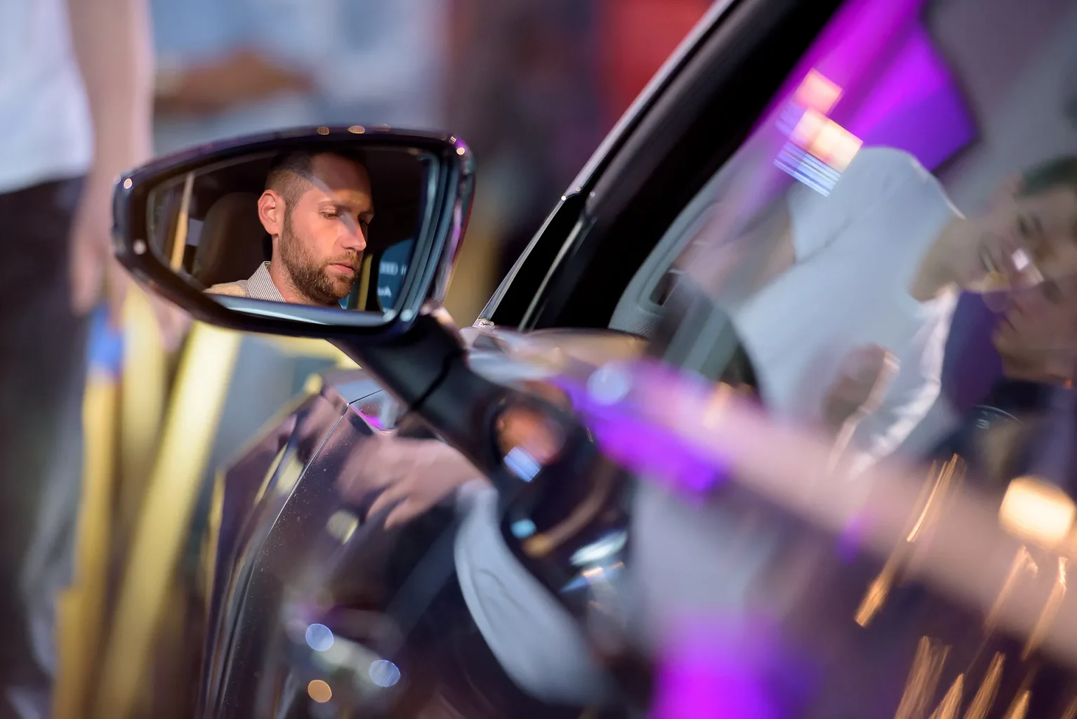 Bemutató rendezvény fotózása, ahol egy férfi ül az autóban és a visszapillantóban látszik az arca.